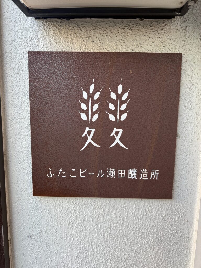 ふたこビール醸造所のロゴと店名が書かれた、おしゃれな鉄製の看板